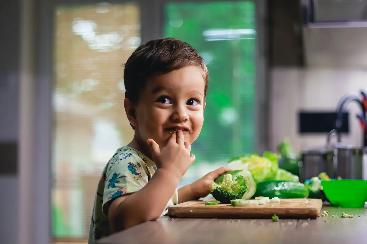 Ein kleiner Junge isst Rohkost-Gemüse