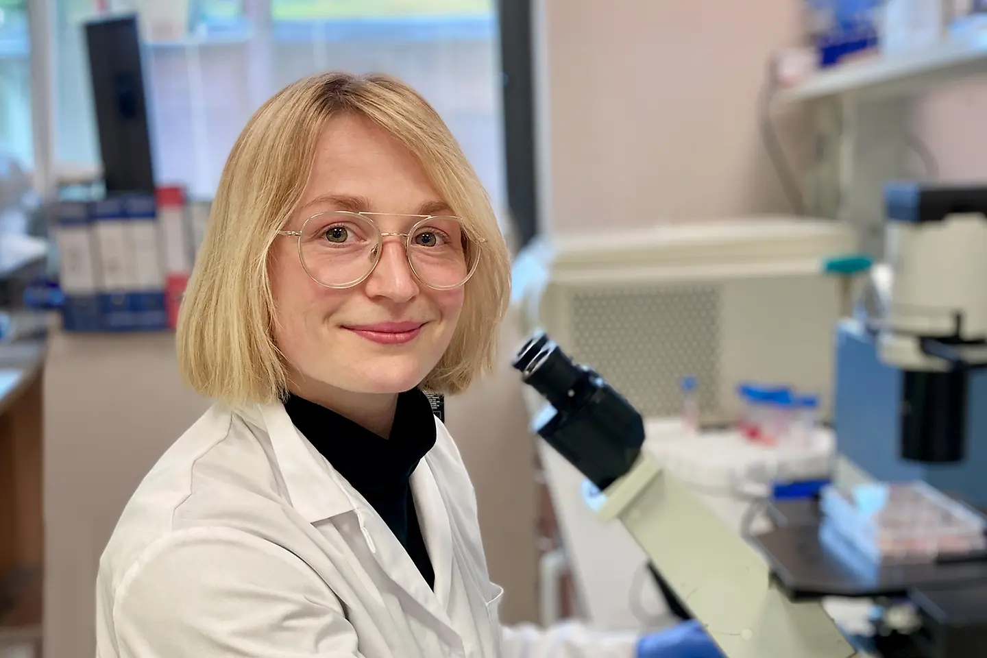 Dr. Ann-Katrin Vlacil sitzt an einem Mikroskop