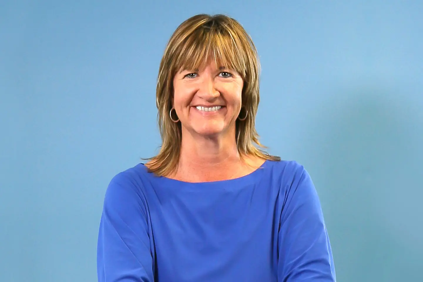 Eine Frau mit langen Haaren lächelt in die Kamera