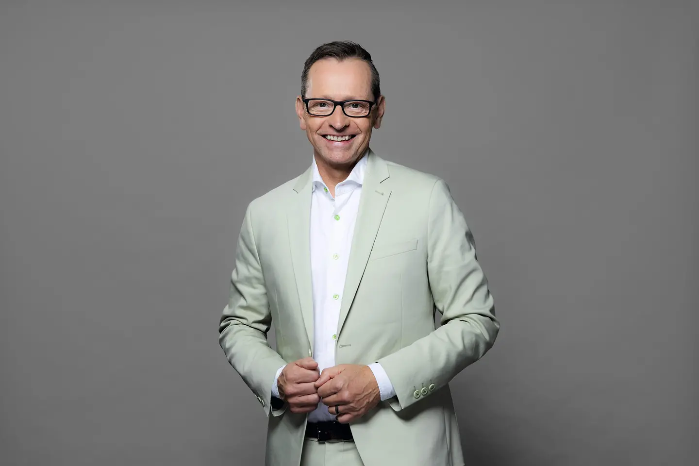 Oliver Kusch steht vor einer grauen Wand.