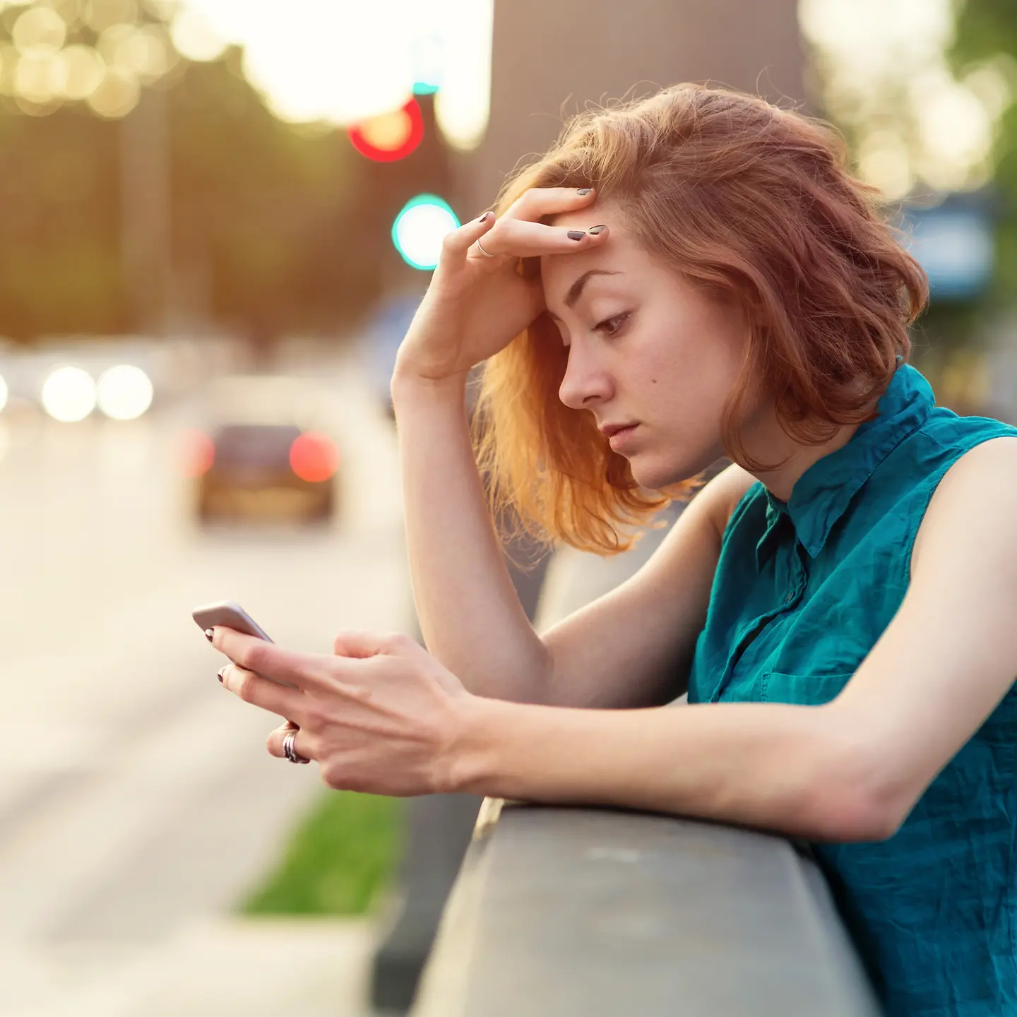 Eine junge Frau schaut gestresst auf ihr Handy