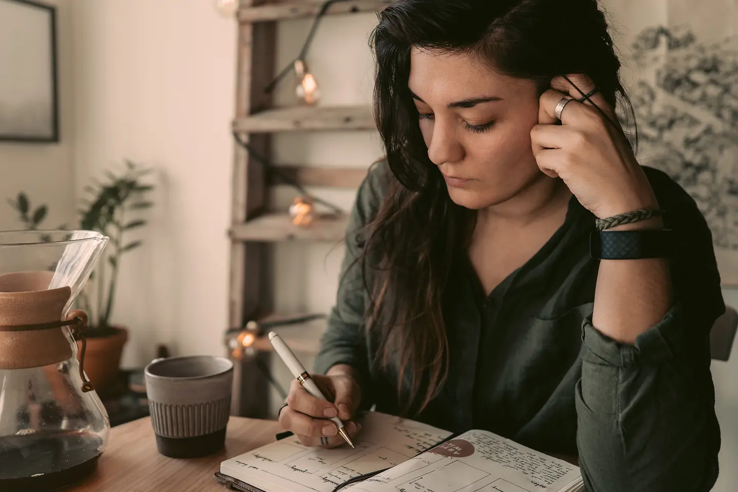 Eine junge Frau schreibt in ihr Bullet Journal