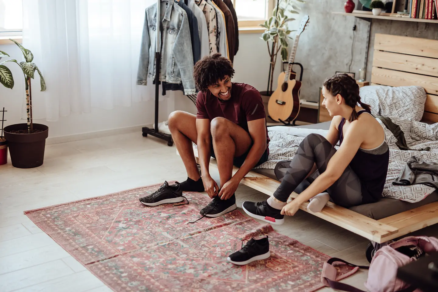Ein junges Paar zieht sich Sportschuhe an