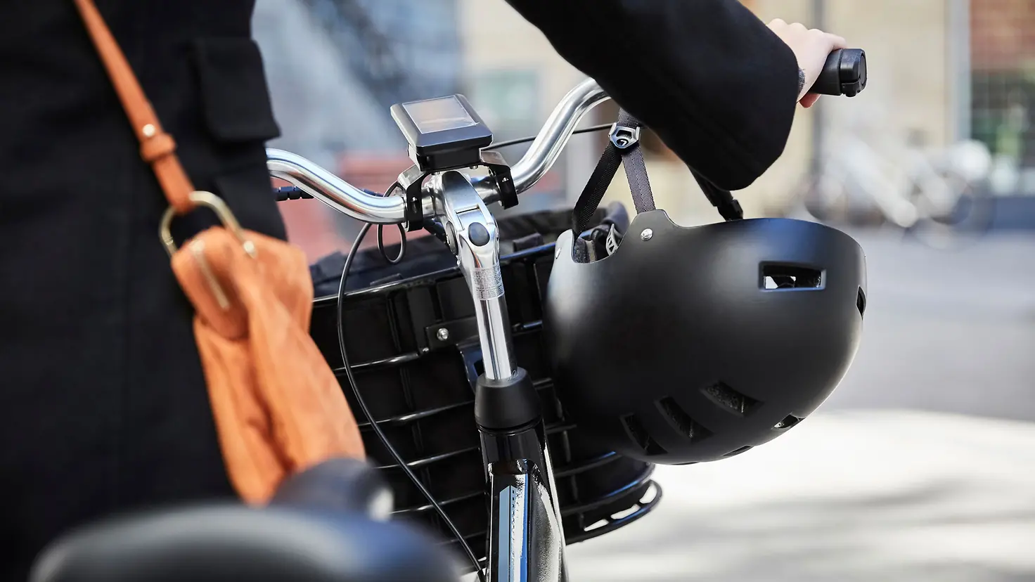 Eine Frau schiebt ihr E-Bike durch die Stadt
