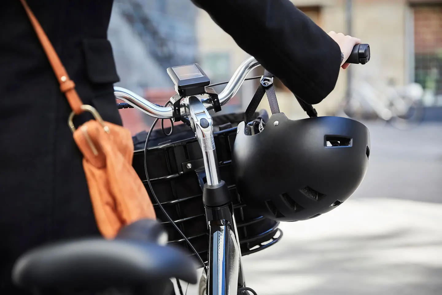 Eine Frau schiebt ihr E-Bike durch die Stadt