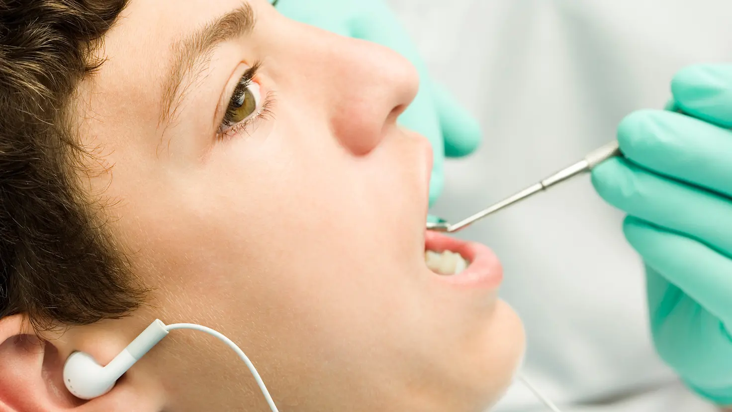 Frau hört Musik beim Zahnarzt