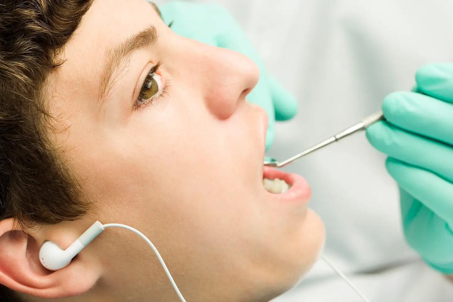 Frau hört Musik beim Zahnarzt