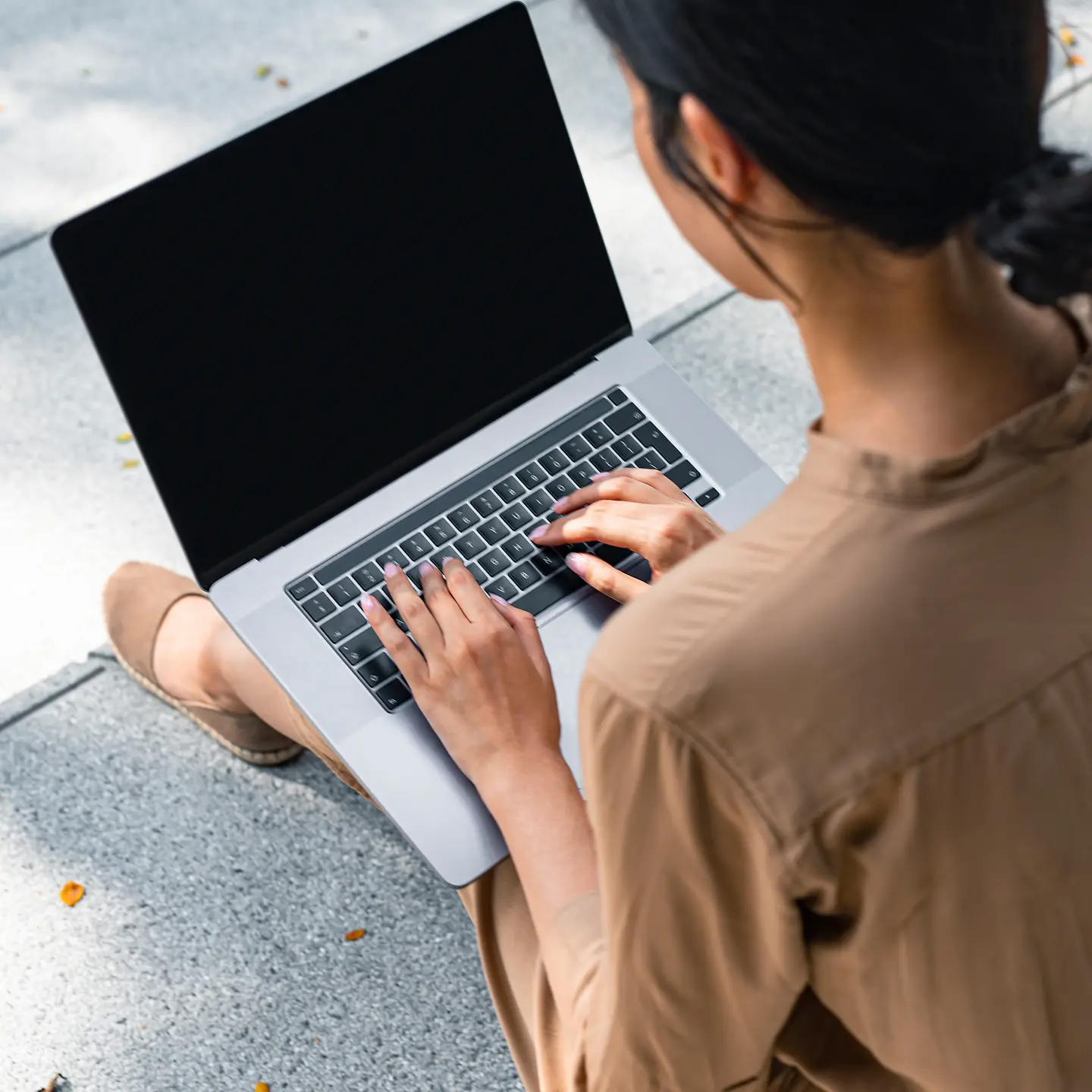 Eine junge Frau auf der Treppe mit Laptop