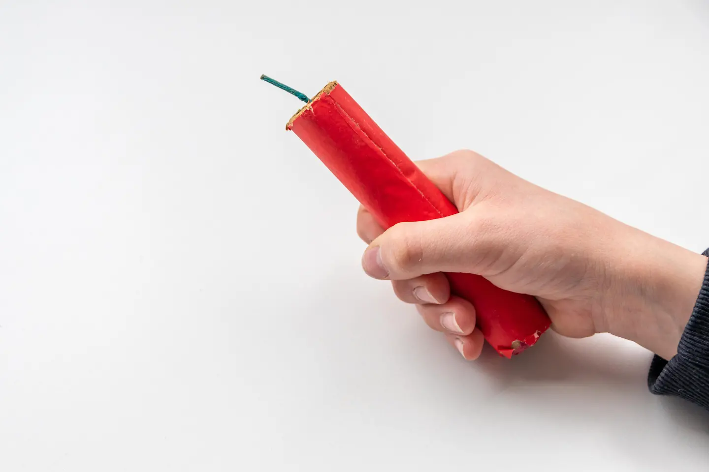 Zu sehen ist eine Kinderhand, die einen Silvesterböller hält