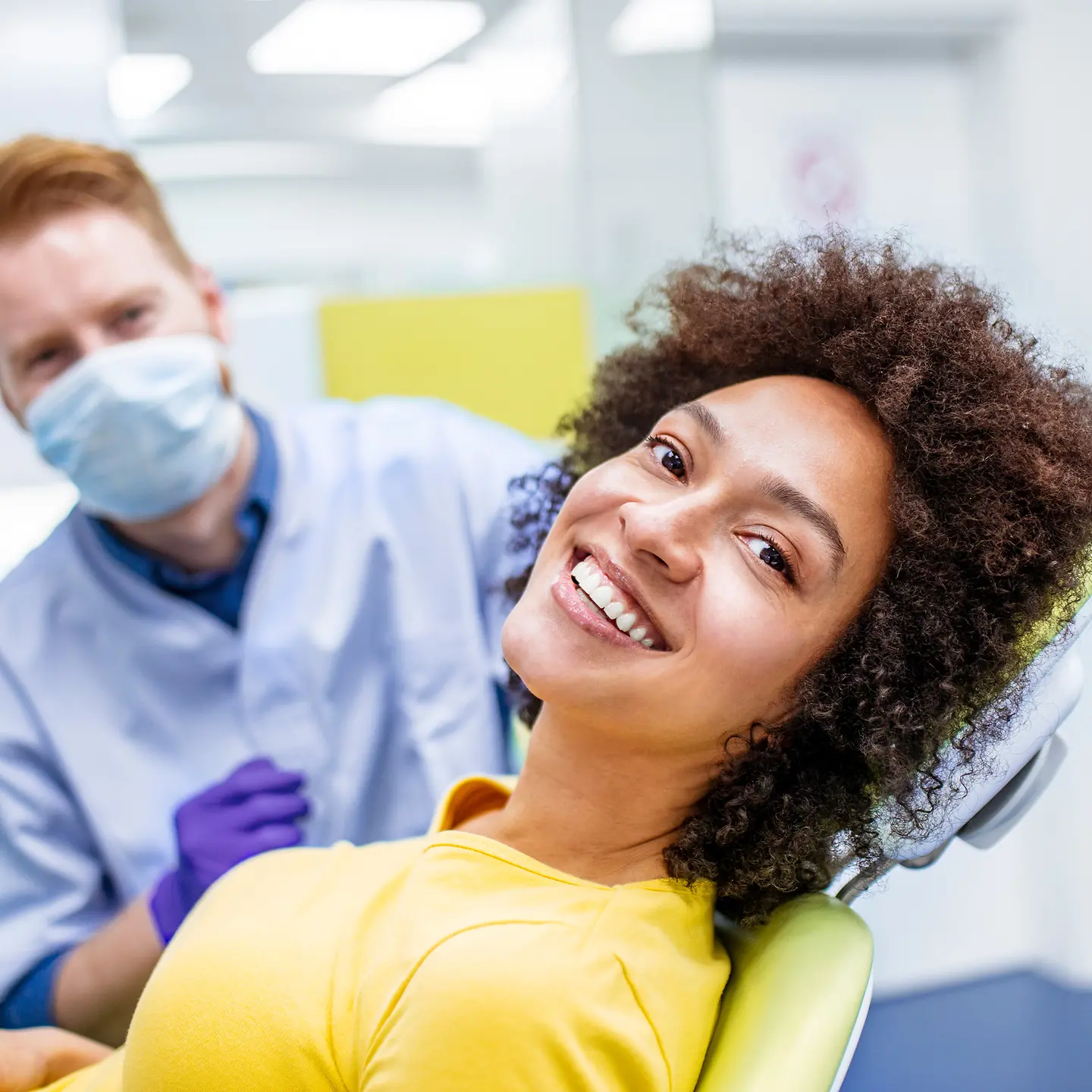 Ein Frau beim Zahnarzt zeigt ein lückenloses Lächeln