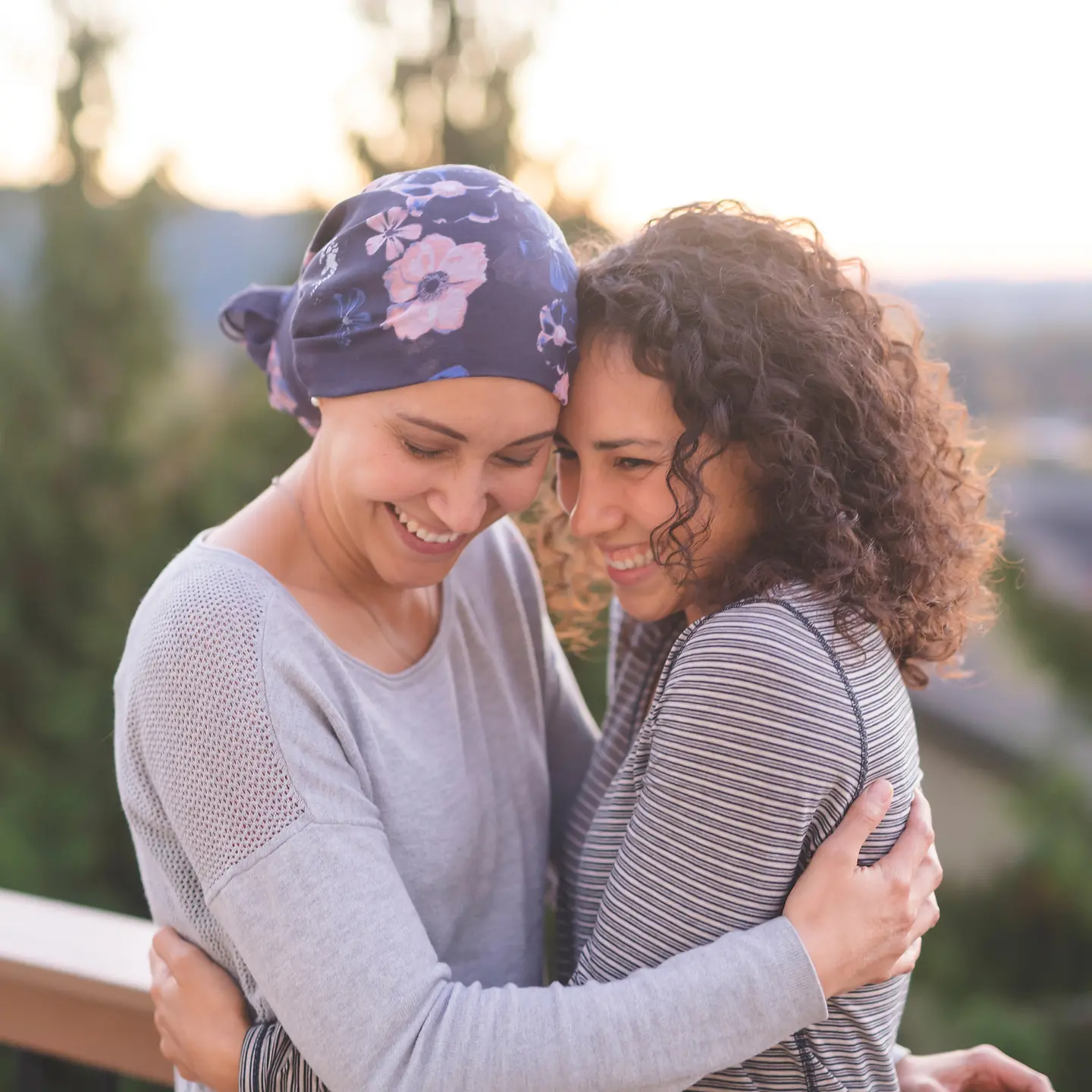 Eine an Krebs erkrankte Frau wird von ihrer Schwester umarmt
