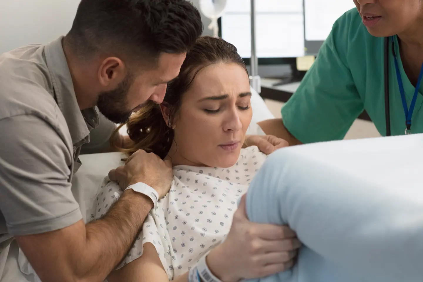 Junge Frau bringt ein Kind zur Welt und wird vom Vater unterstützt