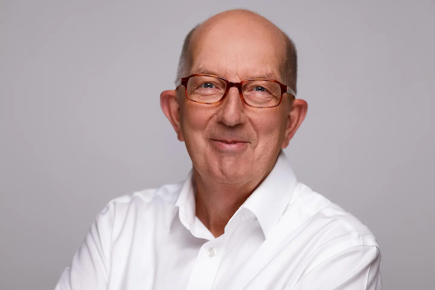 Michael Wäschenbach vor einer grauen Wand.