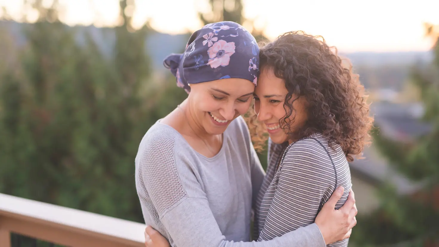 Eine an Krebs erkrankte Frau wird von ihrer Schwester umarmt