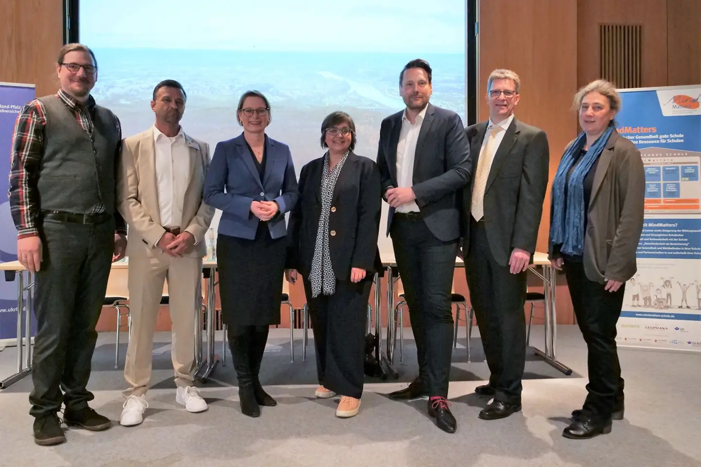 Vertreterinnen und Vertreter der MindMatters-Projektpartner stehen vor einer Wand.