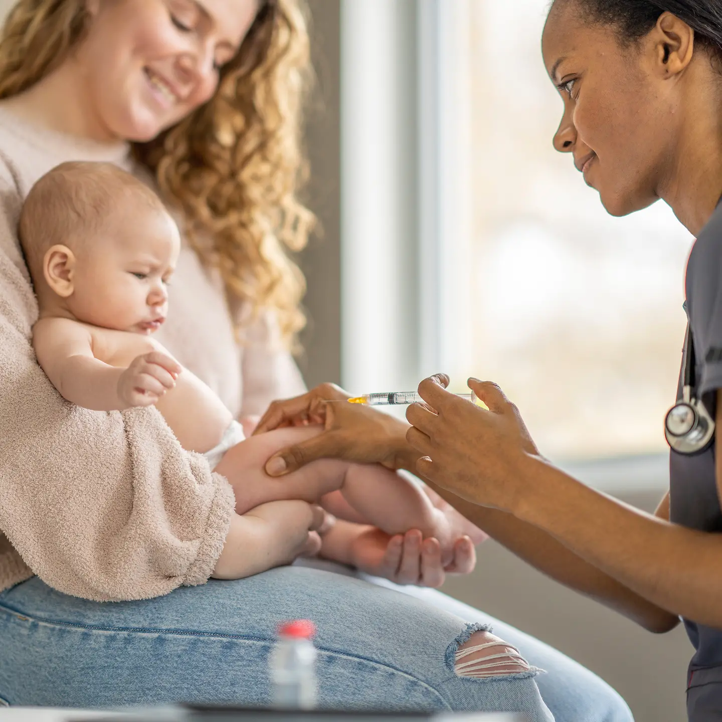 Baby auf dem Arm seiner Mutter bekommt eine Impfung gegen Meningitis-Erreger.