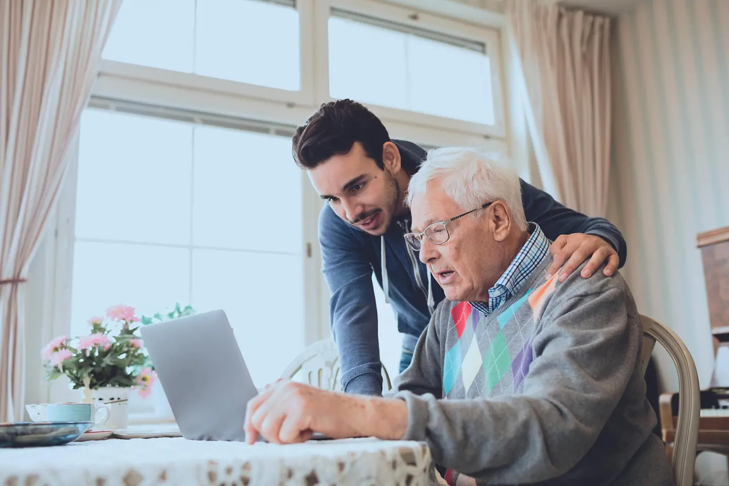 Ein junger Mann absolviert sein FSJ und hilft einem Senioren