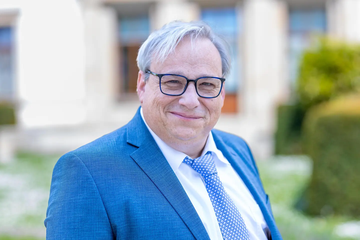 Alwin Theobald steht vor einer Hauswand.