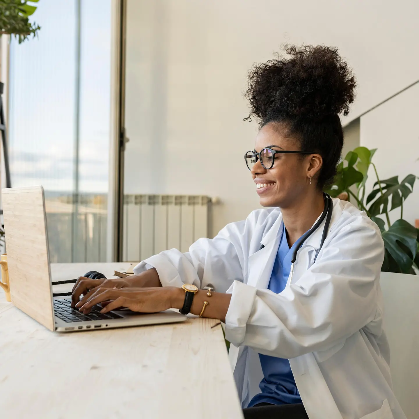 Eine junge Ärztin arbeitet vor einem Laptop