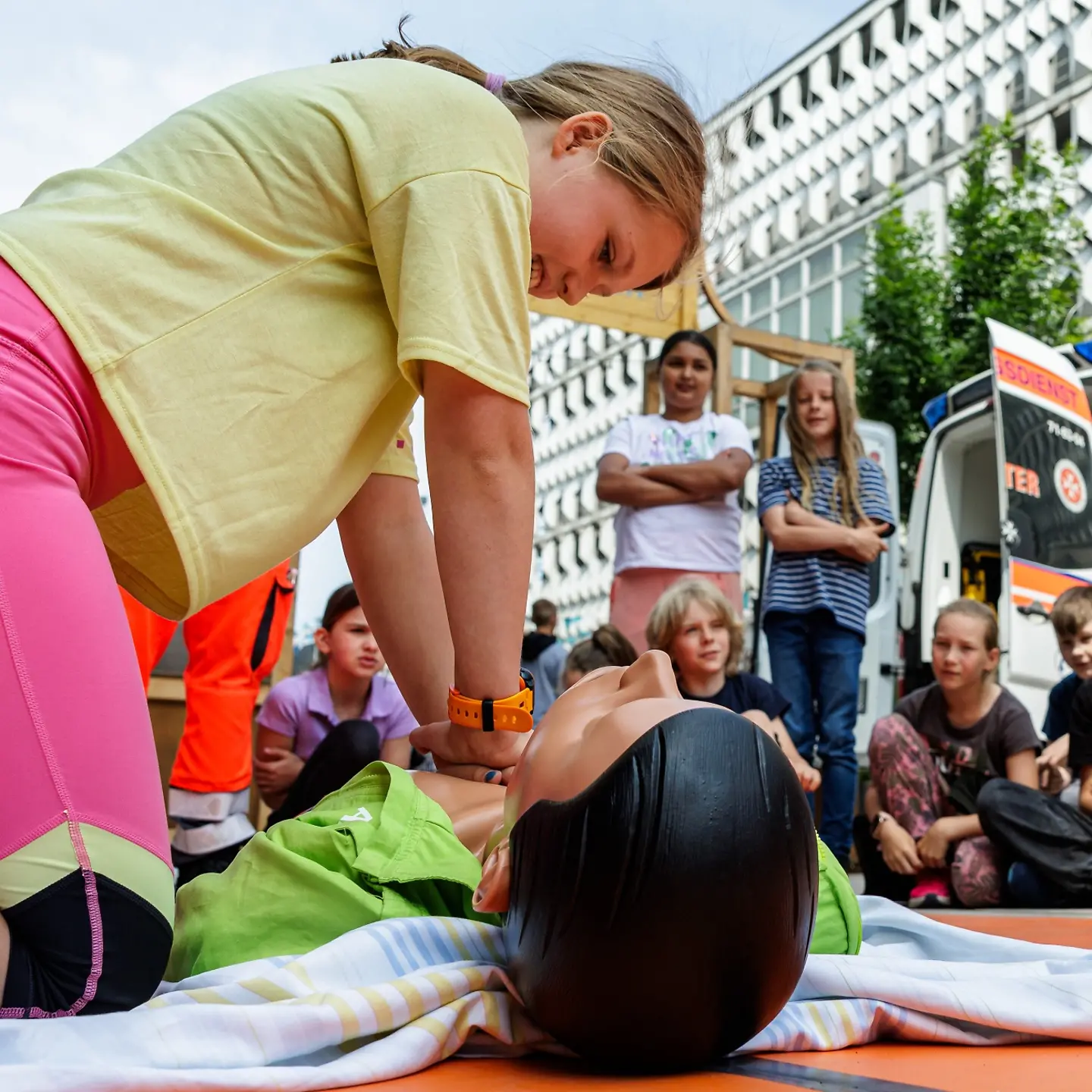 Ein Kind übt die Reanimation an einer Puppe.