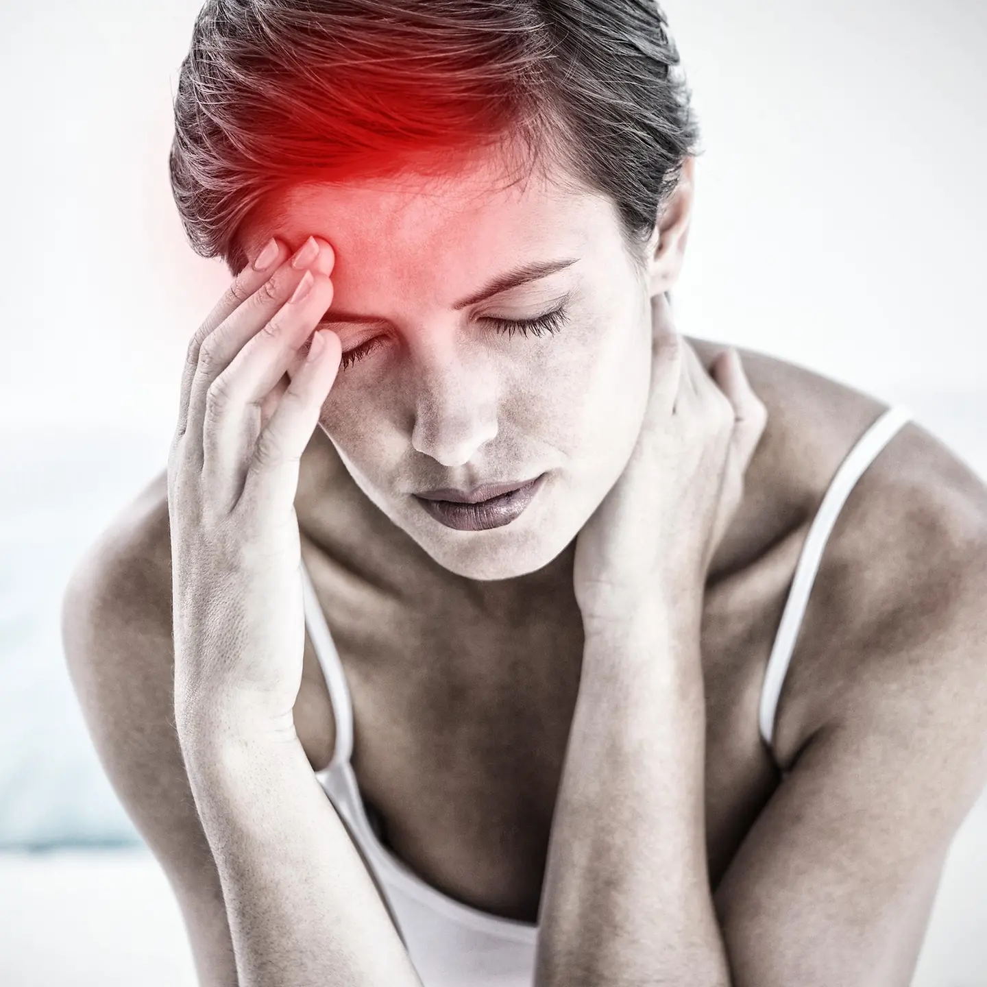 Zu sehen ist eine Frau mit geschlossenen Augen. Mit der einen Hand fasst sie sich in den Nacken, mit der anderen an die Stirn. Die Stelle der Berührung, der vermeintliche Schmerzpunkt, ist rot eingefärbt.