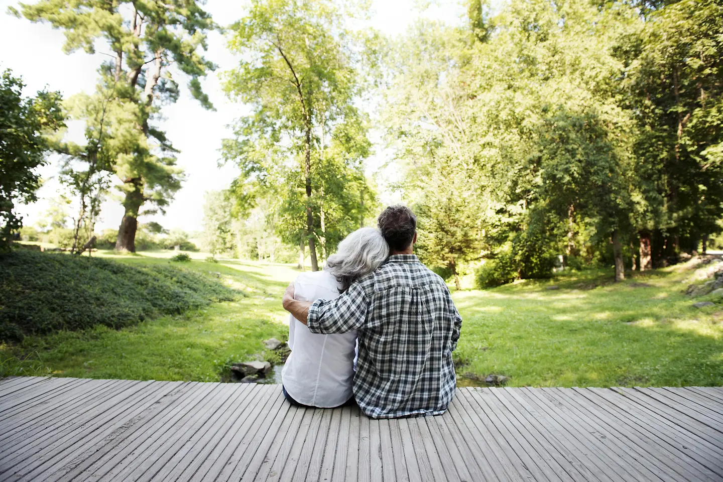 Ein jüngerer Mann sitzt mit einer älteren Frau auf der Veranda im Garten_var