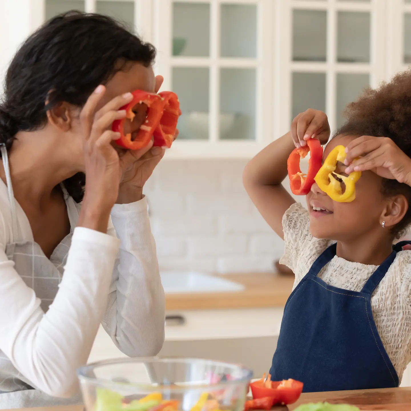 Eine Mutter schneidet mit ihrer Tochter Paprika in Scheiben 