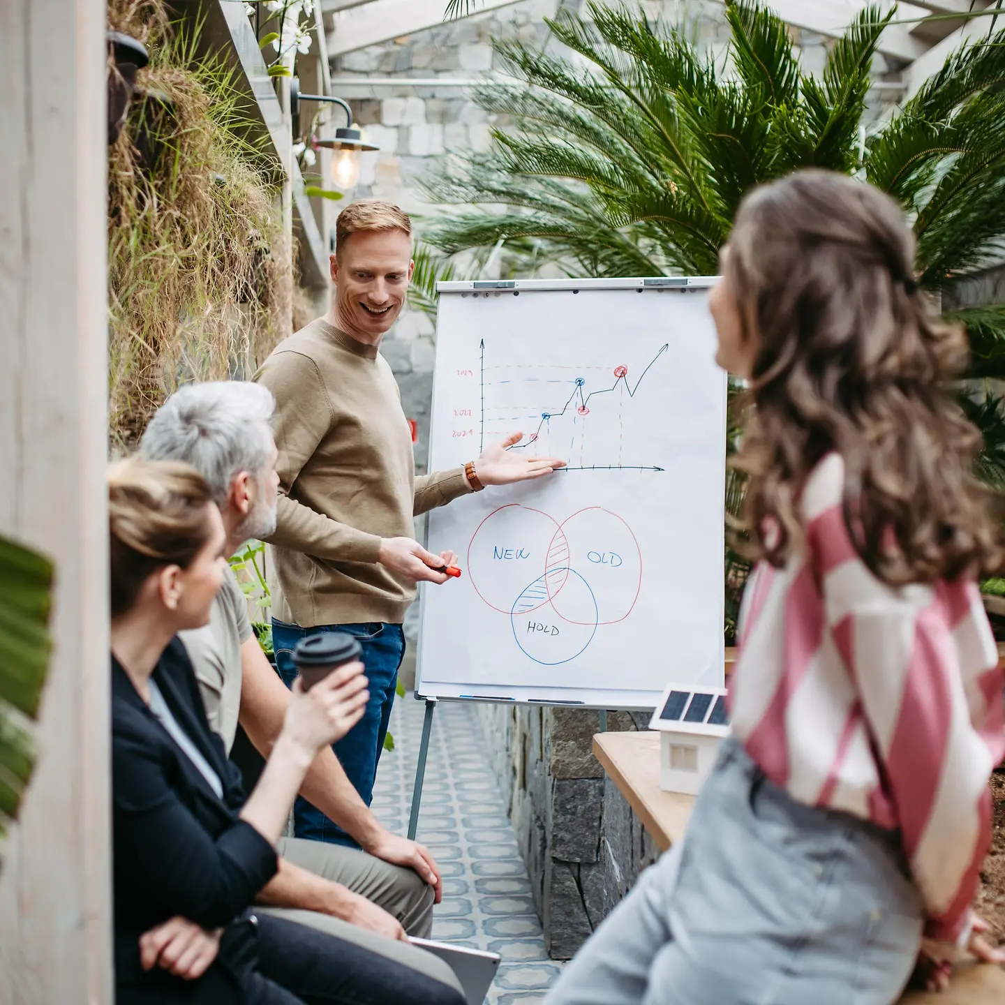 Ein junges Team beim Meeting in einem Gewächshaus
