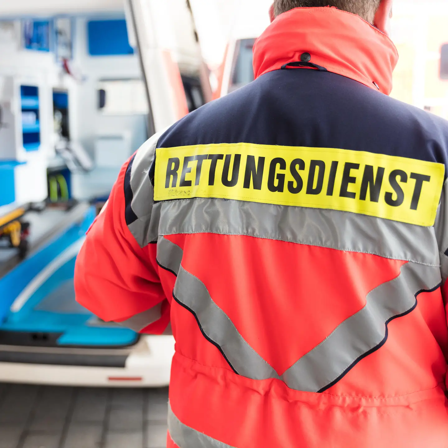 Zu sehen ist ein Rettungssanitäter, der eine Jacke mit der Aufschrift Rettungsdienst trägt.