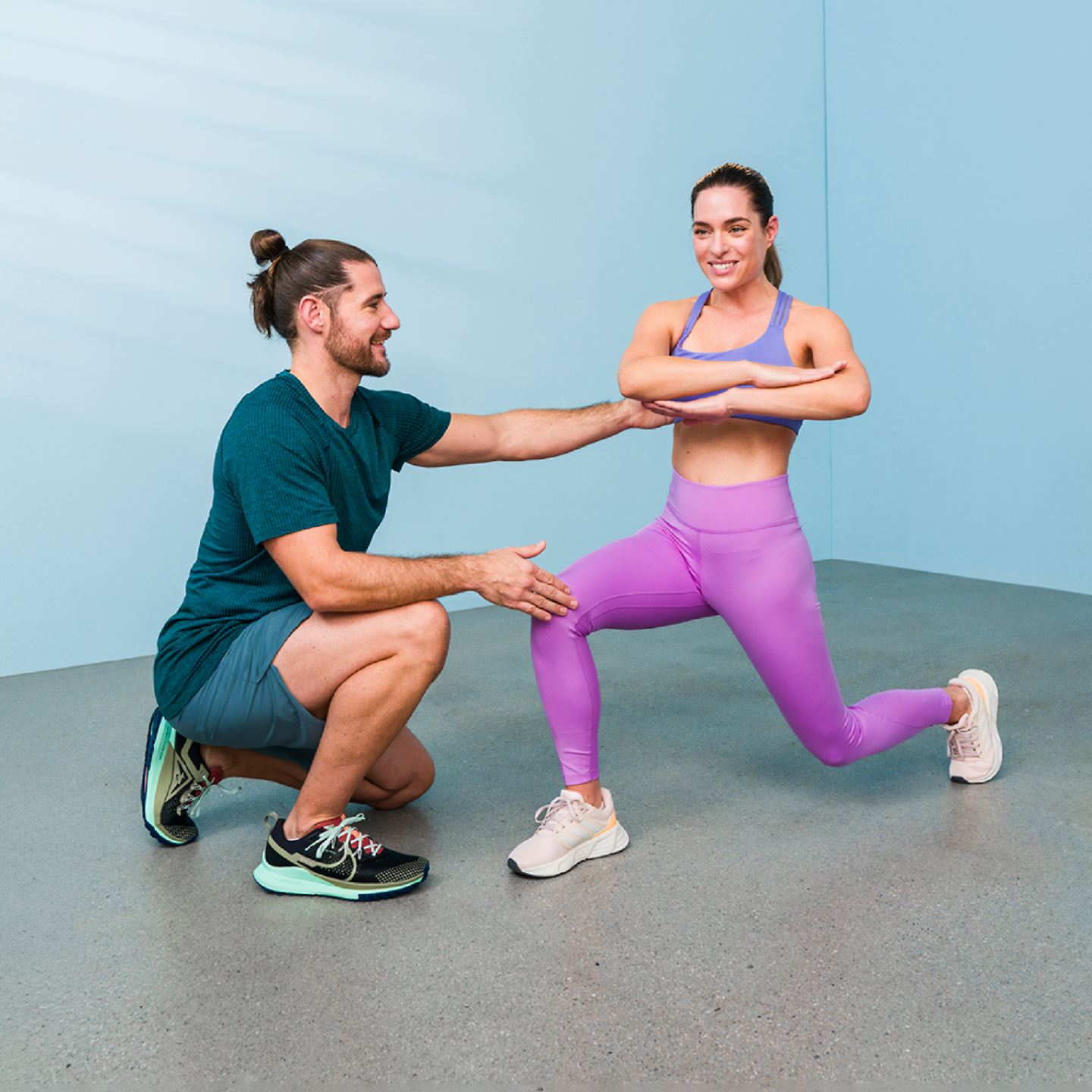 Ein Trainer leitet eine Übung an mit einer Sportlerin