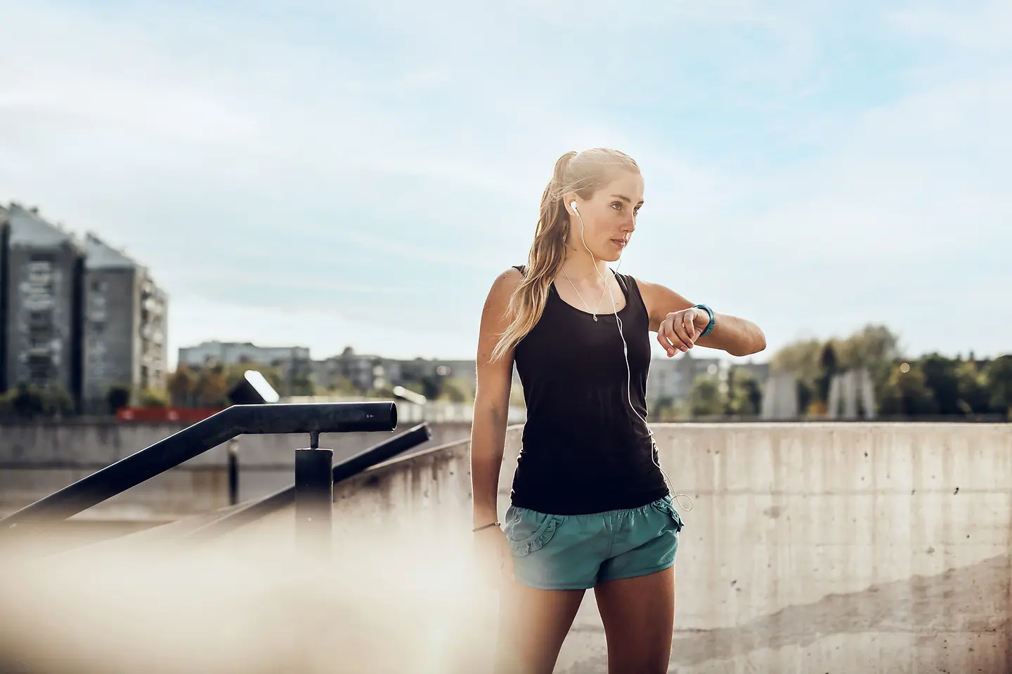 Eine Sportlerin guckt auf ihre Smartwatch