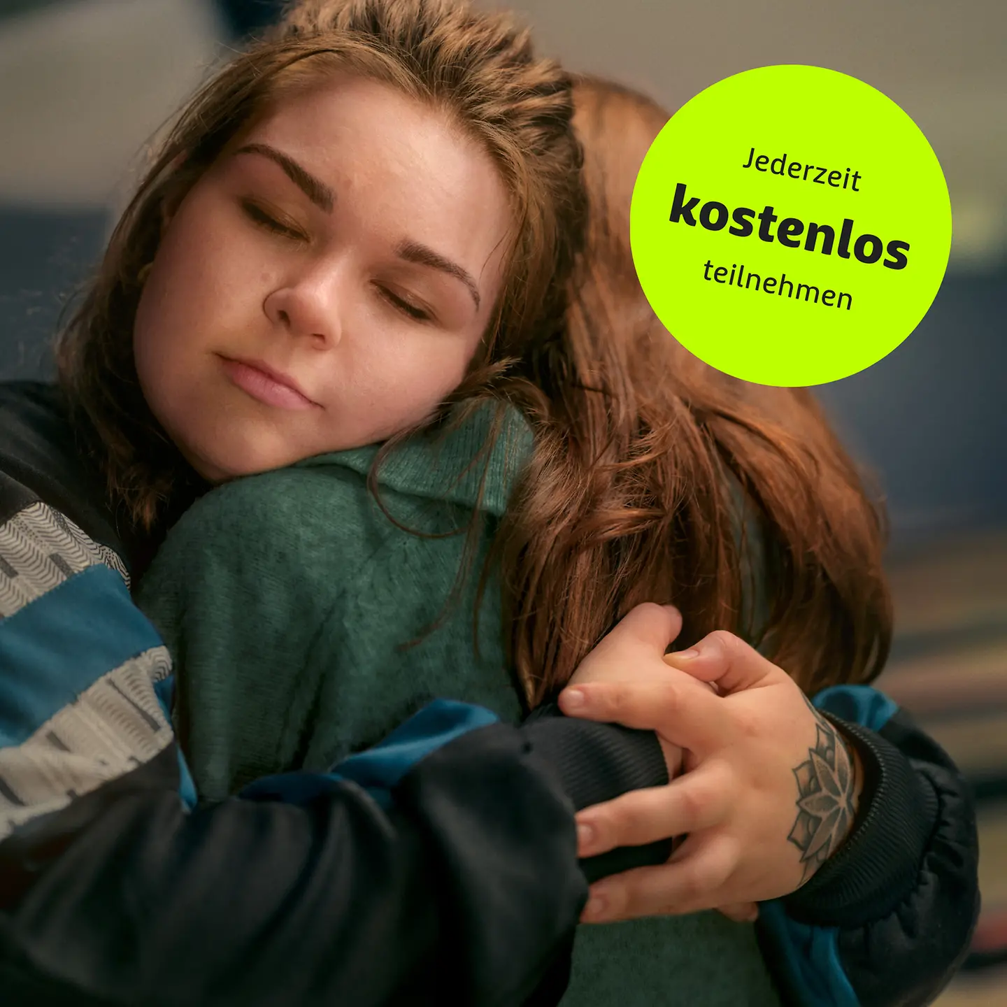 Eine junge Frau umarmt ihre Freundin und hat dabei die Augen geschlossen