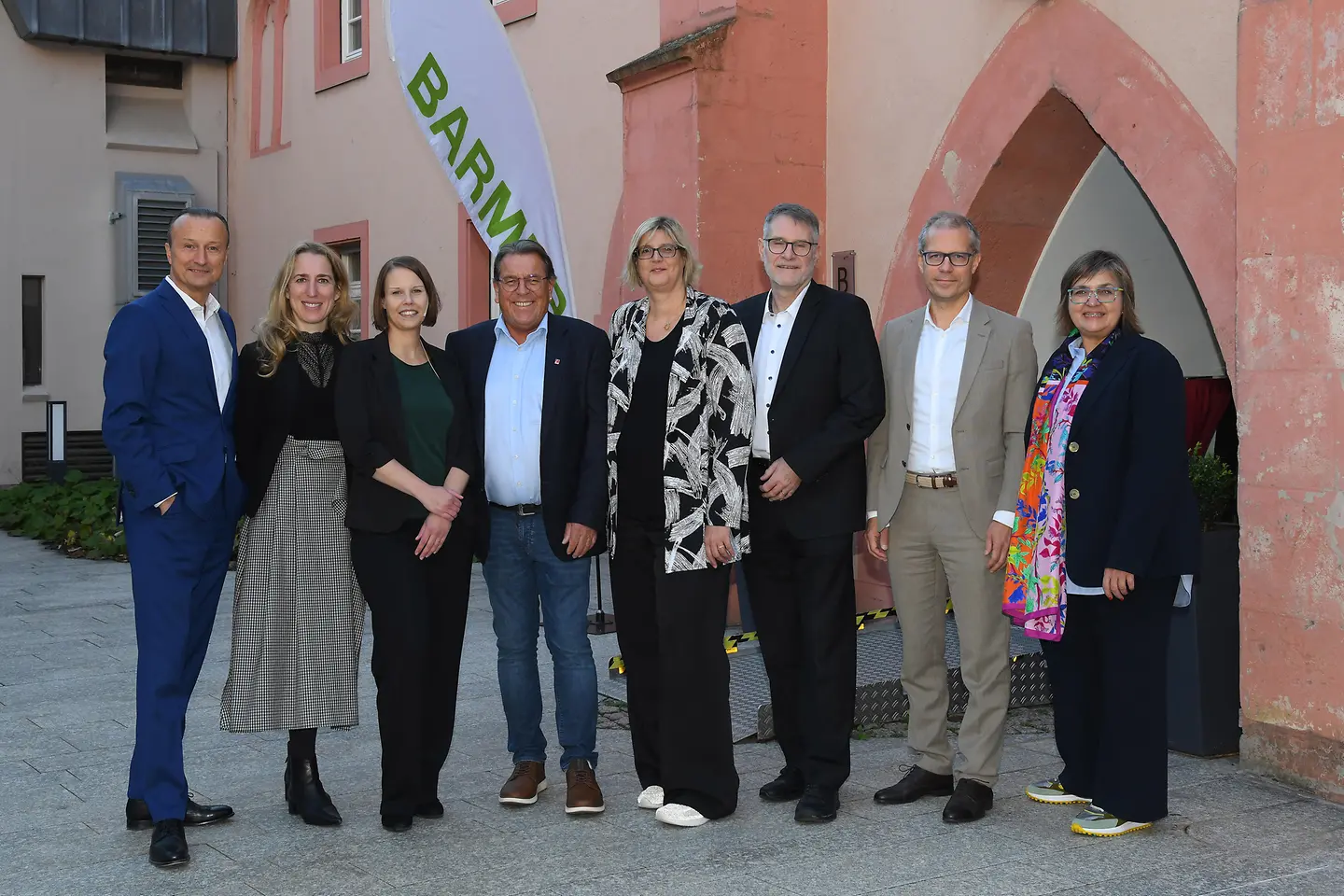 Die Diskutanten stehen vor einer Mauer.