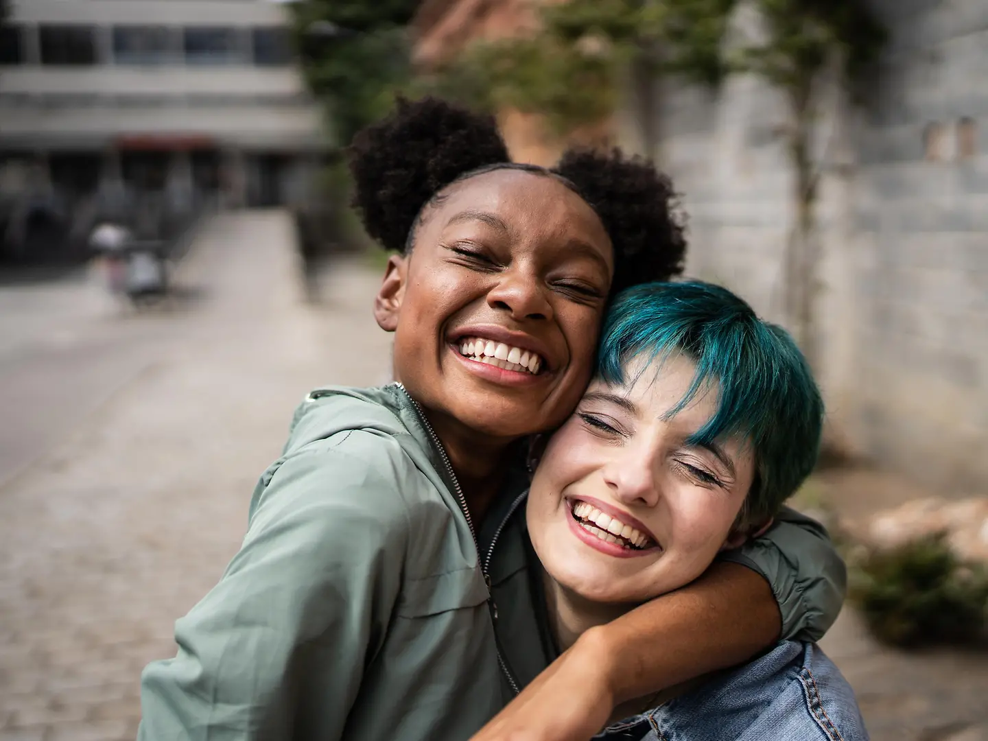 Zwei Freundinnen umarmen sich auf der Straße
