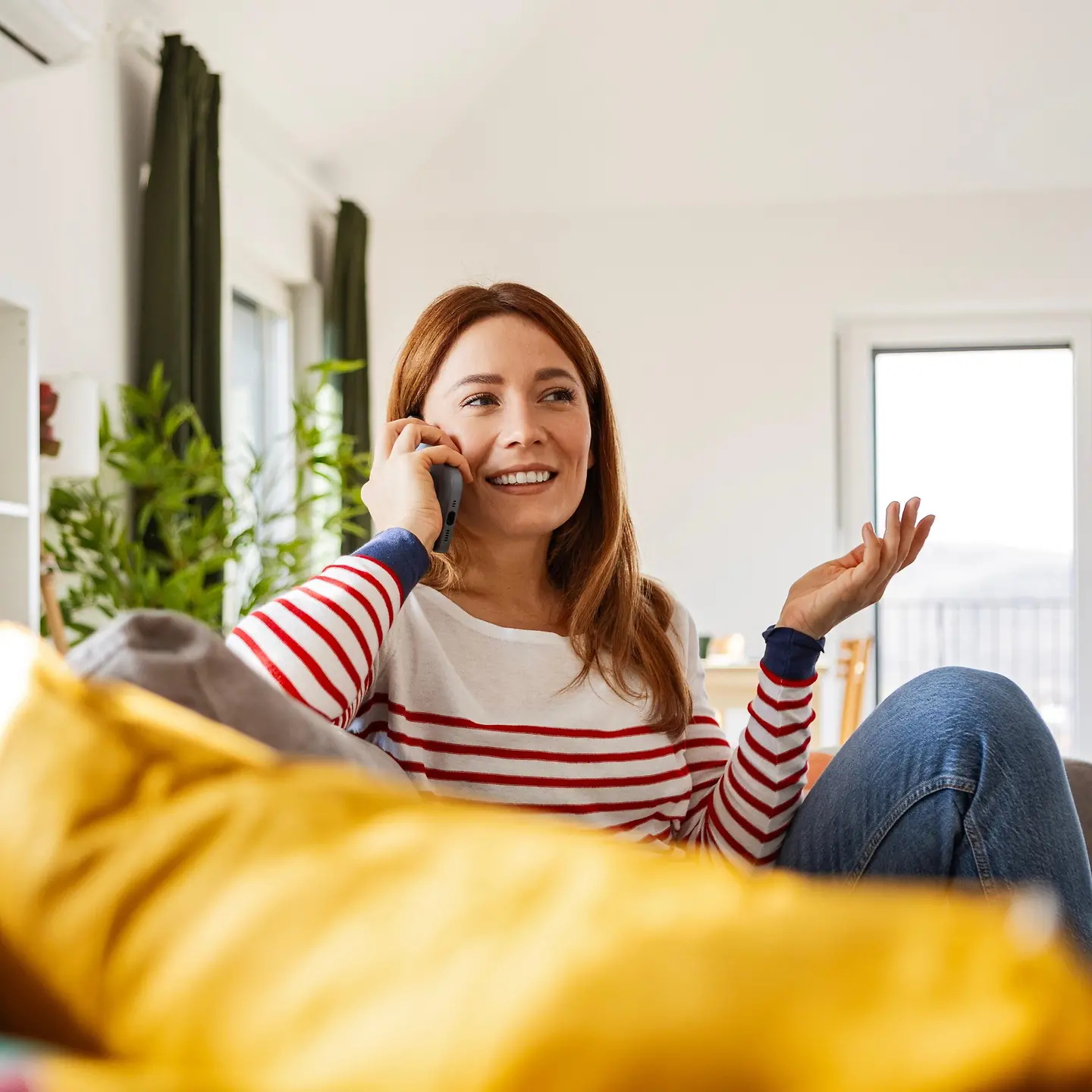 Eine Frau telefoniert entspannt auf dem Sofa