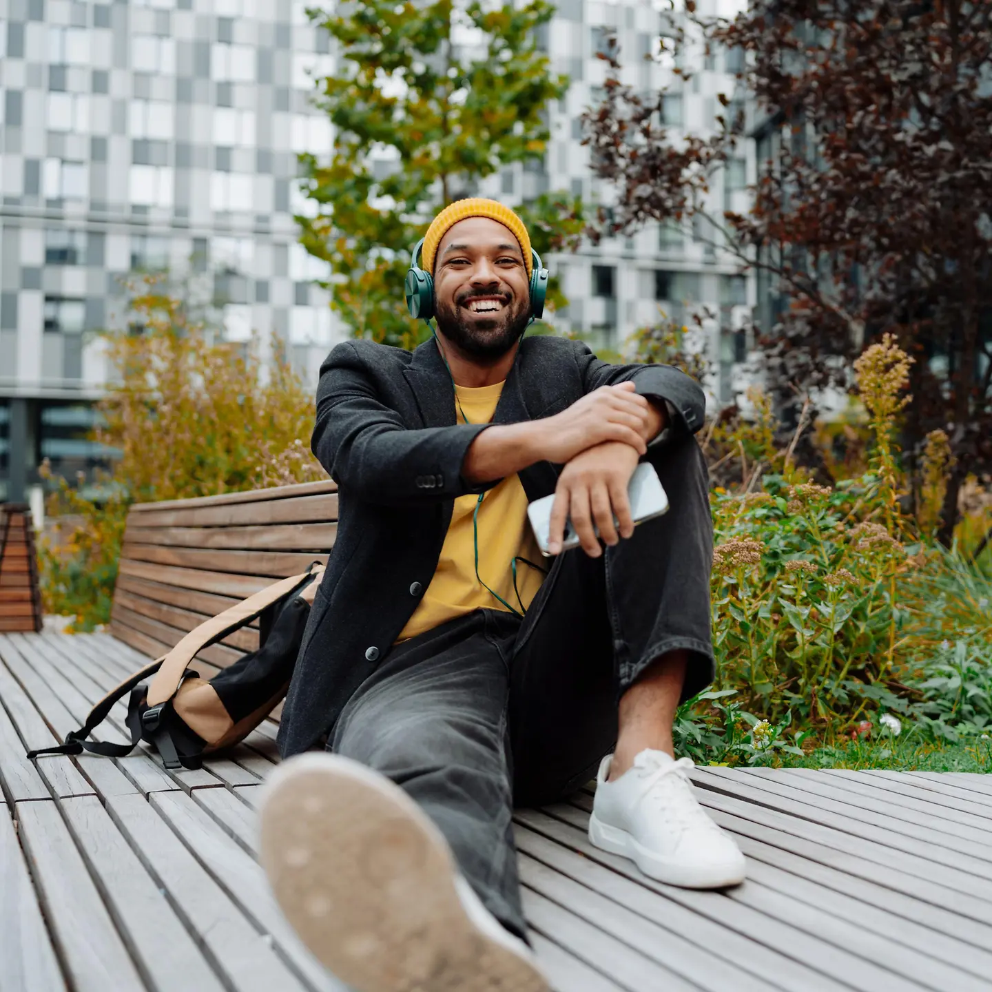 Junger Mann entspannt mit Kopfhörer auf eine Terrasse