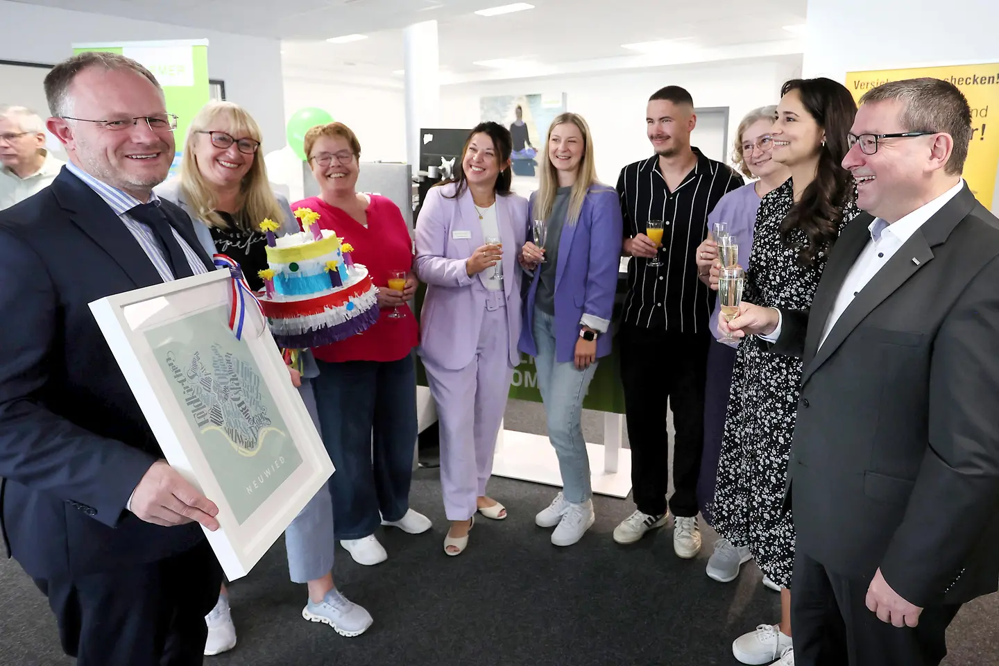 Oberbürgermeister Jan Einig (l.) gratuliert Heike Knapp (2.v.l.), Peter Lauermann (r.) sowie weiteren Barmer-Beschäftigten zur Eröffnung der Geschäftsstelle im alten Krumholz-Gebäude.