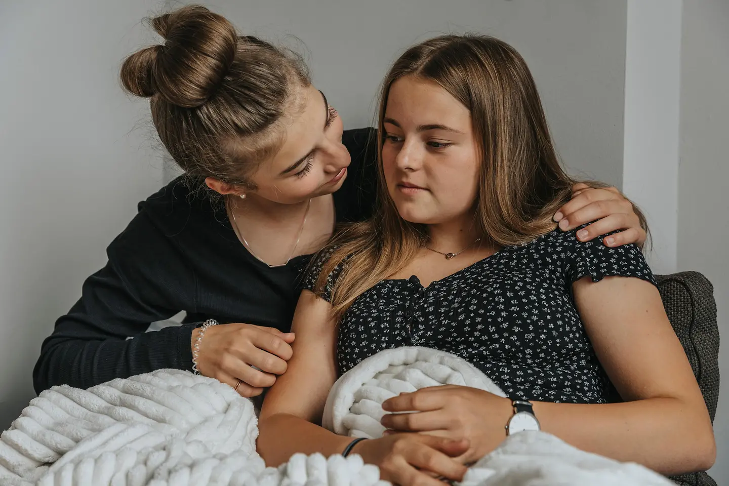 Ein Mädchen wird von einer jungen Frau getröstet