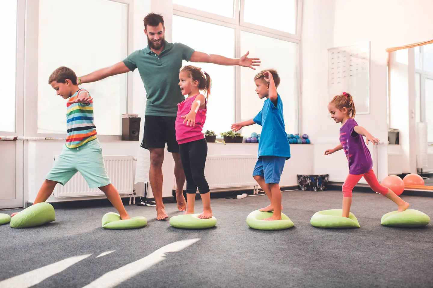 Zu sehen sind Kinder beim Sport mit Trainer