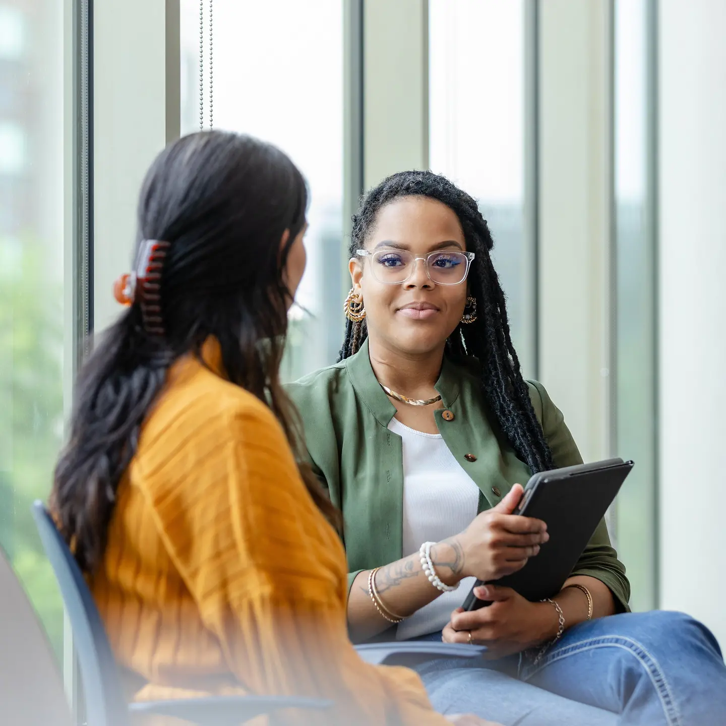 Zwei Frauen unterhalten sich in einem modernen Büro