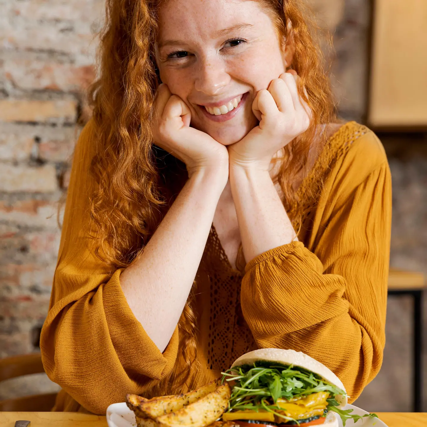 Eine Frau mit Unverträglichkeit sitzt am Esstisch und isst einen Burger