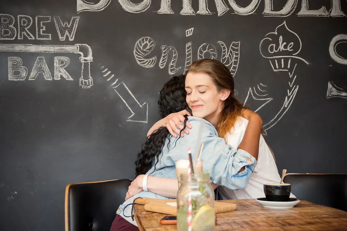 Eine junge Frau tröstet eine Freundin, die unter ihrer Trennung leidet. 