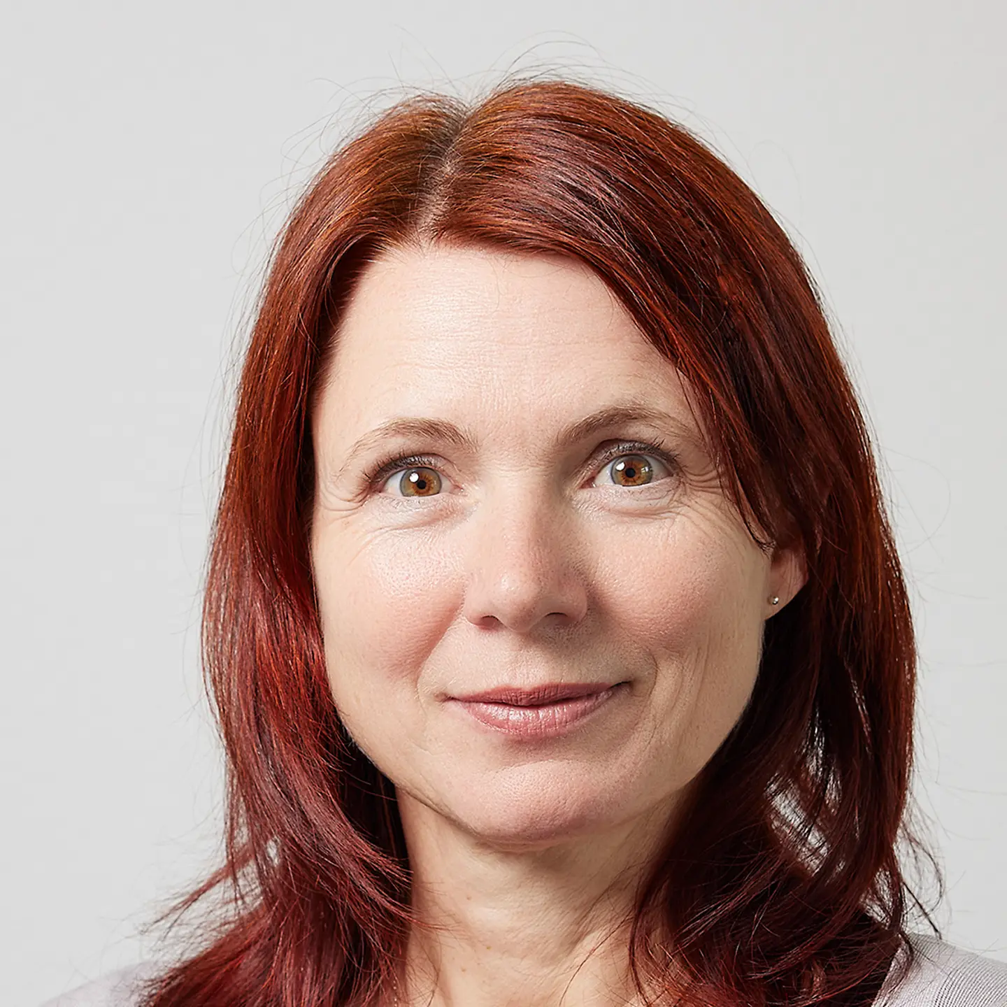 Eine Frau mit langen Haaren lächelt in die Kamera