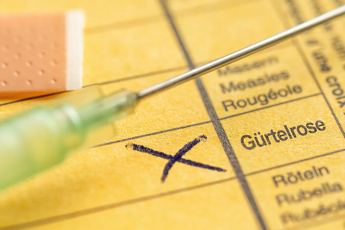 Zu sehen ist ein gelber Impfausweis mit einem Kreuz bei Gürtelrose