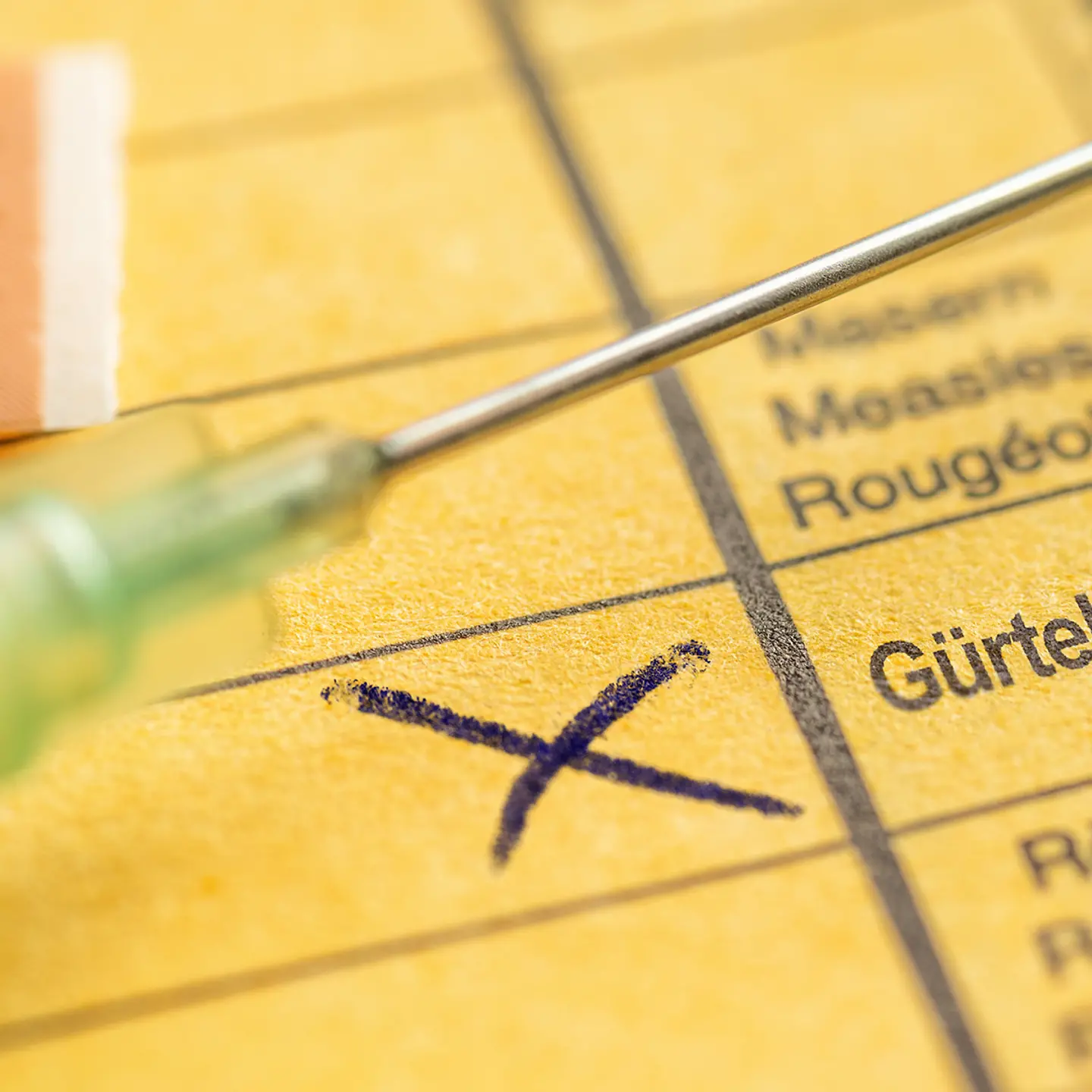 Zu sehen ist ein gelber Impfausweis mit einem Kreuz bei Gürtelrose