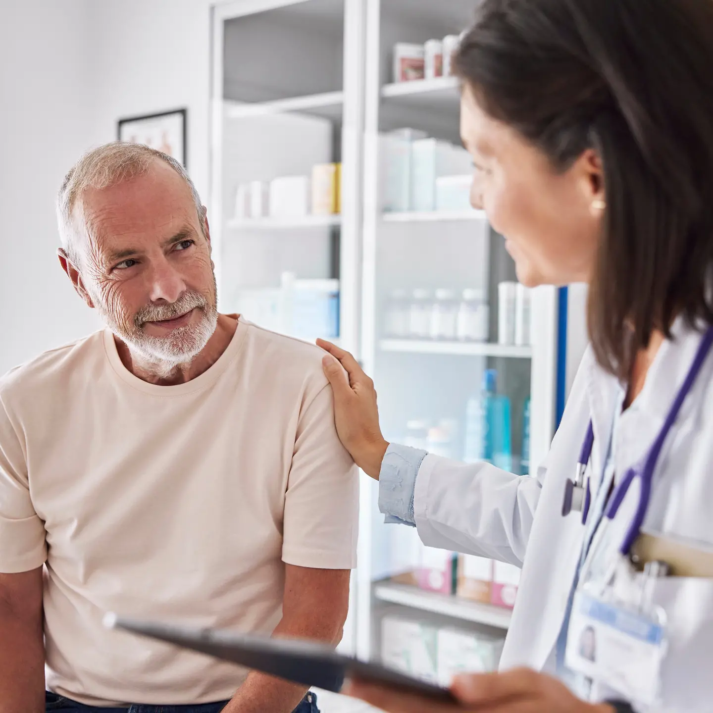 Älterer Mann und Ärztin im Behandlungszimmer im Gespräch