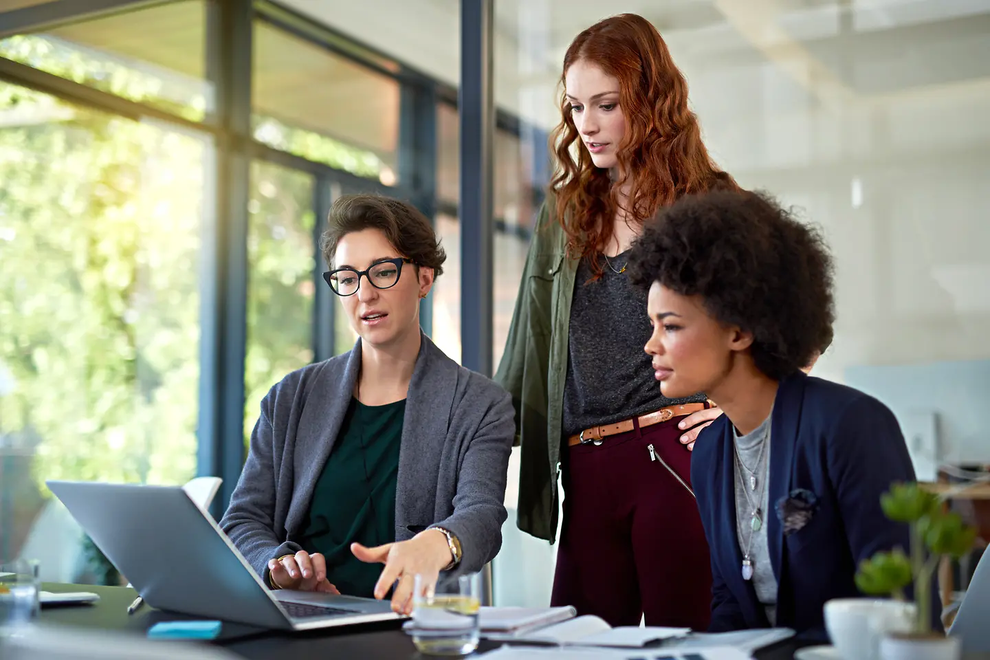 Drei Frauen schauen auf einen Monitor