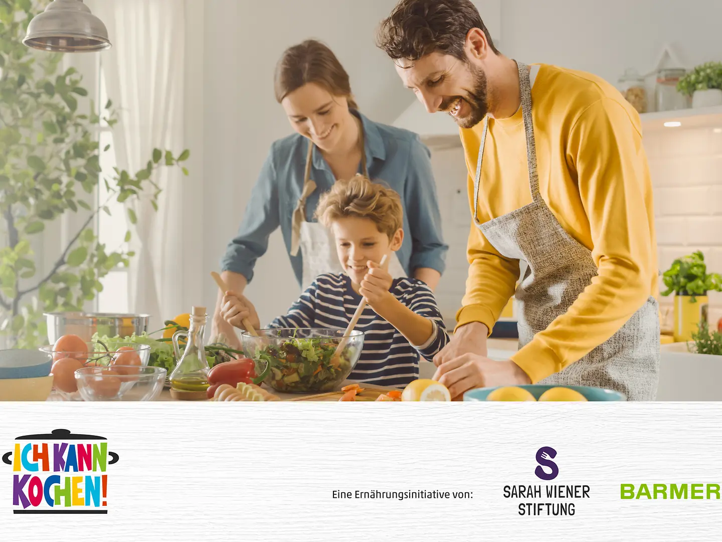 Eine Familie bereitet gemeinsam Essen zu - mit Logos von Barmer, Sarah-Wiener-Stiftung und Ich kann kochen!
