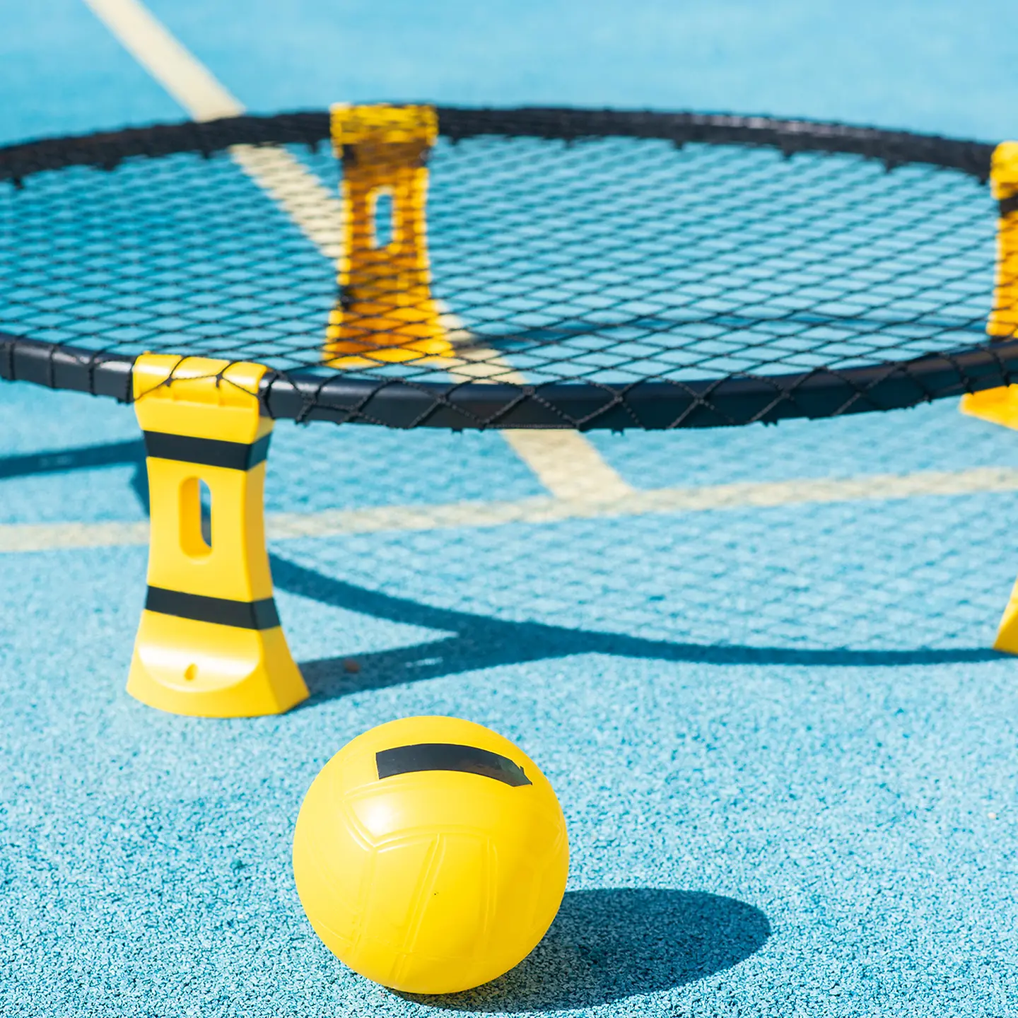 Auf dem Bild zu sehen sind die Spielgeräte, die es für das Spiel Roundnet benötigt. Ein kleines Trampolin, das vielleicht 30 Zentimeter hoch ist und ein kleiner Ball.