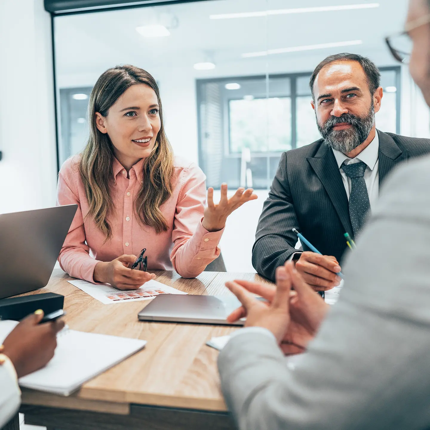 Ein Team in Businesskleidung diskutiert an einem Konferenztisch